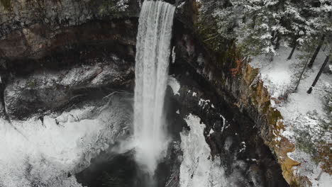 Herrliche-Wasserkaskade-Von-Brandywine-Falls-In-Whistler,-Kanada-Mit-Schneebedecktem-Regenwald-Im-Winter