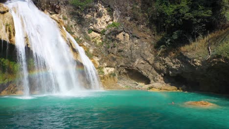 Girl-diving-into-tropical-waterfall-pool,-paradise-idyllic-travel-destination