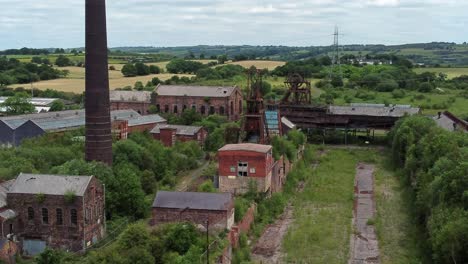 Abandoned-old-overgrown-coal-mine-industrial-museum-buildings-aerial-view-reverse-right