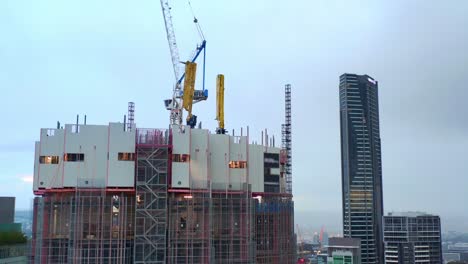 Aerial-Side-View-of-443-Queen-Street-Building-Construction-Site-with-Tower-Crane-on-Top,-Brisbane-City-Australia