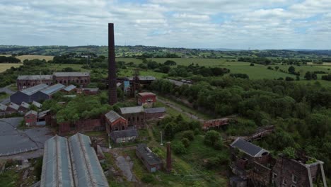 Abandoned-old-overgrown-coal-mine-industrial-museum-buildings-aerial-view-orbit-right