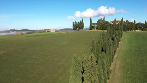 Beautiful-landscape-scenery-of-Tuscany-in-Italy---cypress-trees-along-white-road---aerial-view