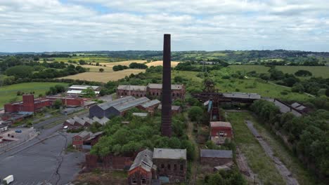 Abandoned-old-overgrown-coal-mine-industrial-museum-buildings-aerial-view-push-in-left-orbit