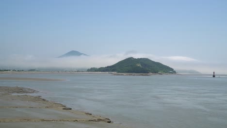 Yellow-sea-low-tide-in-Ganghwado-island-in-South-Korea,-Red-navigational-buoy-floating-in-between-islands