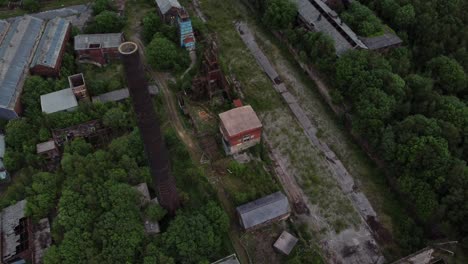 Abandoned-old-overgrown-coal-mine-industrial-museum-buildings-aerial-chimney-top-down-view