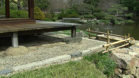 Corner-of-Japanese-house-with-gravel-drainage-apron-and-pond-in-background