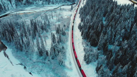 Drone-Shot-Of-Train-Moving-Slow-On-Railroad-Track-Through-Fir-Trees-At-Glacier-National-Park-Of-Canada-In-British-Columbia