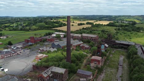 Abandoned-old-overgrown-coal-mine-industrial-neglected-buildings-aerial-view-orbit-right-reveal