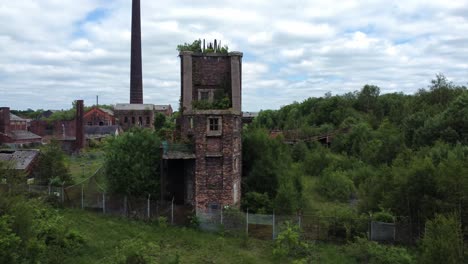 Abandoned-Chatterley-Whitfield-overgrown-coal-mine-industrial-museum-buildings-aerial-view-low-orbit-left