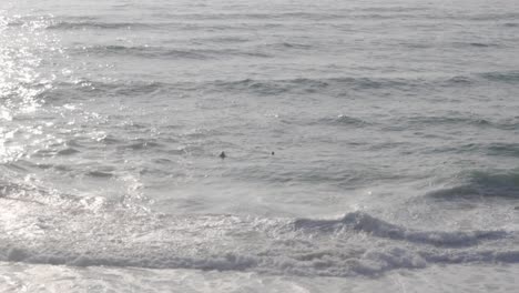 Two-Surfers-Floating-in-the-Waves-at-Guincho-Beach-in-Portugal