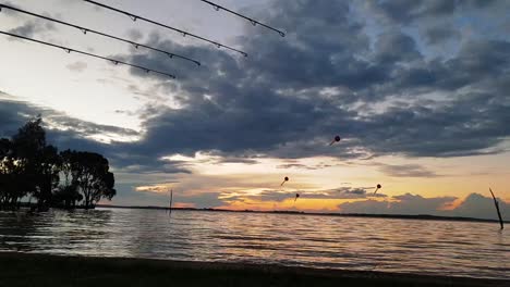 Carp-fishing-rods-with-bait-in-the-water-waiting-for-a-bite-with-a-perfect-sunset-in-the-distance