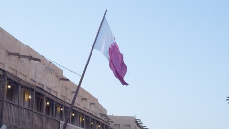 La-Bandera-Qatar-Ondeando-En-El-Viento-Lateralmente-En-Un-Asta-De-Bandera-Durante-El-Día,-Cerrar