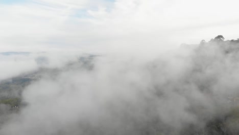 Drone-view-across-mist-on-mountain-at-morning