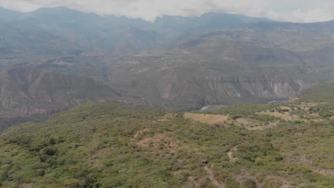 Tirar-Al-Frente-Por-Encima-De-Los-Campos-Con-Vistas-A-Las-Montañas-Y-Al-Río-En-Una-Tarde-Nublada