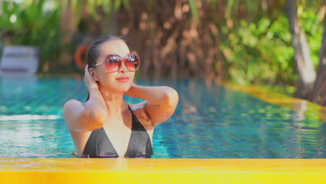 Sexy-Sinnliche-Frau-Glattes-Nasses-Haar-Mit-Den-Händen,-Während-Sie-Im-Privaten-Schwimmbad-In-Bali,-Indonesien,-Zeitlupenporträt-Steht