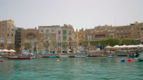 Maltesischer-Hafenblick-Vom-Fahrenden-Boot-Mit-Architektonischen-Stadtgebäuden-In-Malta---4k-Handheld-Heiß