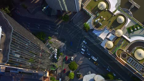 Aerial-top-down-view-of-Passing-Cars-on-Eagle-Street-intersection-next-to-Riverside-Dining-complex,-Brisbane-City-Australia