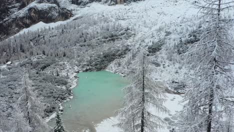 Drone-Shot-Of-Beautiful-Blue-Glacial-Lake,-Lago-Di-Sorapiss,-Dolomites,-Italy-in-winter