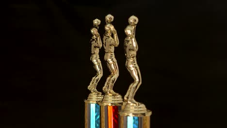 Three-Volleyball-trophies-for-winners-isolated-on-black