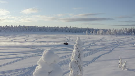 Drohnen-Luftaufnahme,-Die-Einem-Schneemobilfahrer-Auf-Tiefem-Schnee-Mit-Geschwindigkeit-In-Der-Natur-Schwedens-Folgt