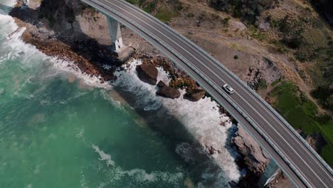 Traffic-At-Sea-Cliff-Bridge-Over-Crashing-Waves-In-Summer-At-NSW,-Australia