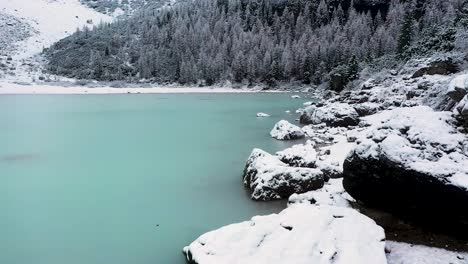Aerial-Shot-Of-Beautiful-Blue-Glacial-Lake,-Lago-Di-Sorapiss,-Dolomites,-Italy-in-winter