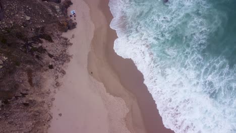 AERIAL-Ascending-Top-Down-View-Shot-of-the-Waves-at-Praia-da-Ursa,-Portugal