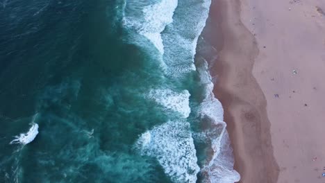 Descending-Shot-of-the-Waves-at-Guincho-Beach,-Portugal