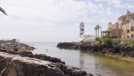 A-Person-in-the-Water-by-the-Santa-Marta-Lighthouse-in-Cascais,-Portugal
