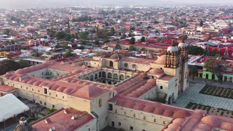 Downtown-Oaxaca,-Mexico,-Flying-Above-Santo-Domingo-de-Guzman-Church-Complex-and-Downtown-With-Cityscape-Skyline-in-Background,-Drone-Aerial-View