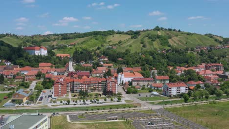 Aerial-arc-shot-moving-around-the-center-of-the-town-of-Lendava,-Slovenia-on-a-bright-summer-day