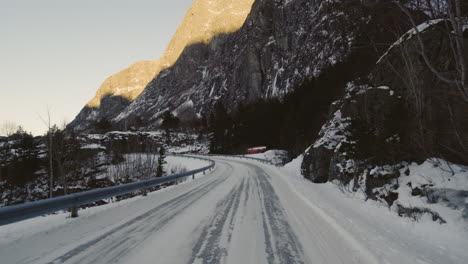 Slippery-Road-Covered-In-Snow-By-The-Mountainside-In-Eresfjord-In-Norway---moving-shot