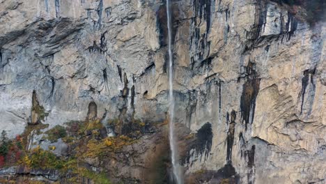 Giant-waterfall-over-the-mountain-rocks-falling-down-on-a-bright-day-in-Lauterbrunnen,-Switzerland
