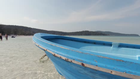 Blaues-Fischerboot-Aus-Holz,-Das-Auf-Seichten-Gewässern-Am-Strand-Von-Saracen-Bay-Festgemacht-Ist
