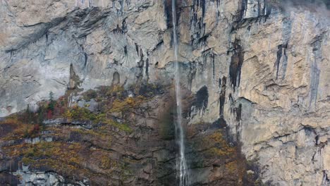Giant-waterfall-over-the-mountain-rocks-falling-down-on-a-bright-day-in-Lauterbrunnen,-Switzerland