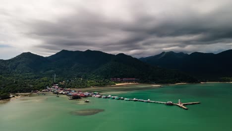 4K-Zeitraffer-Drohnenaufnahmen,-Die-über-Pier-Und-Leuchtturm-Auf-Der-Insel-Koh-Chang-Schweben,-Mit-Niedrigen-Cumulus-Wolken,-Die-Sich-über-Den-Bergigen-Dschungel-In-Thailand-Bewegen