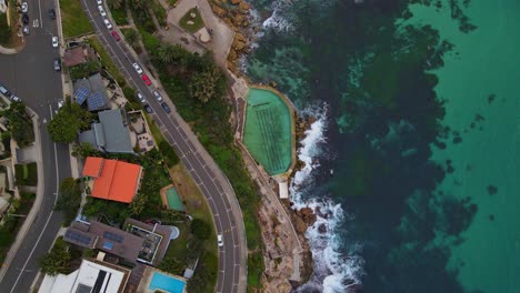 Top-View-Of-Bronte-Baths-And-Coastal-Road-Of-Calga-Place-At-The-Oceanfront-Of-Bronte-Beach-In-New-South-Wales,-Australia