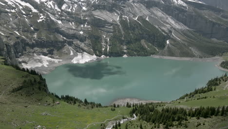 Cloud-draws-black-shadow-on-the-light-blue-water-of-the-Oeschinensee-in-the-Swiss-Alps