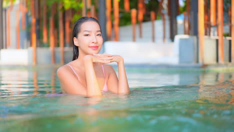 Zeitlupe-Einer-Jungen-Vorbildlichen-Thailändischen-Frau,-Die-Sich-In-Einem-Schwimmbadwasser-Eines-Luxuriösen-Spa-resorts-In-Pattaya-Entspannt---Gesichtsnahaufnahme