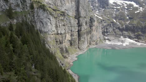 Vertikale-Bergklippen,-Die-Sich-Im-Hellblauen-Wasser-Des-Oeschinsees-In-Der-Schweiz-Spiegeln