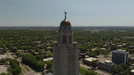 Drone-Orbits-Around-Nebraska-State-Capitol-Tower,-with-View-of-The-Sower