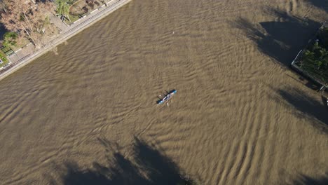 Adventure-seekers-rowing-on-single-longboat,-on-waters-of-river-Tigre-during-day
