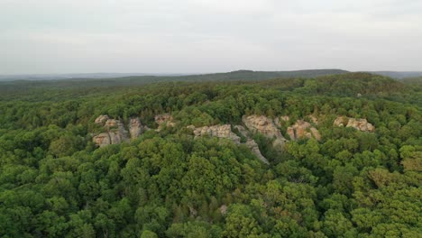 Beautiful-rocky-landscape-covered-in-dense-forest,-aerial-view