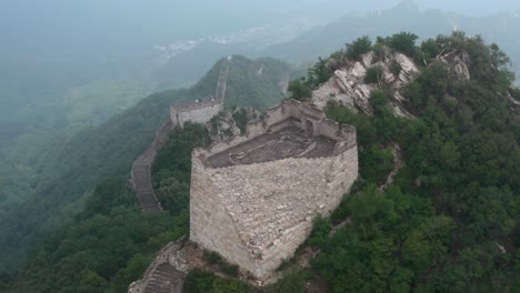 Old-deteriorated-square-lookout-tower-of-Great-Wall-of-China-on-top-of-mountain-summit-on-a-cloudy-day