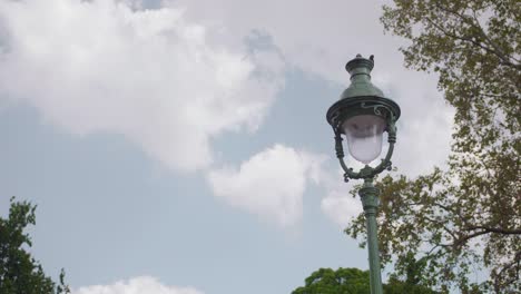 Static-view-of-typical-French-street-lamp-on-partially-cloudy-summer-day-in-Paris,-France