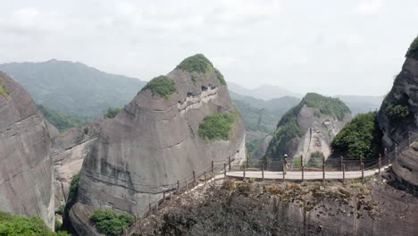 Aerial:-female-hiking-up-Bajiao-Shan-mountain-steps,-amazing-Chinese-hike