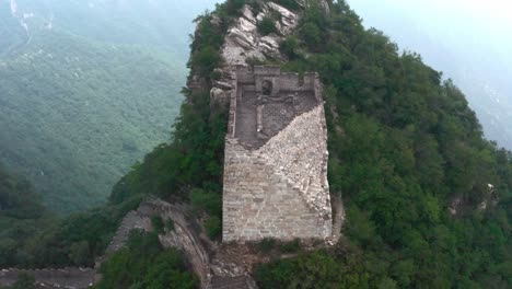 Old-deteriorated-square-lookout-tower-of-Great-Wall-of-China-on-top-of-mountain-summit-on-a-cloudy-day
