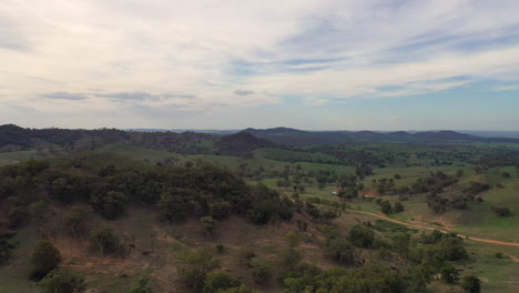 Aerial-wide-shot-flying-over-hills-and-trees-in-a-rural-landscape-Mudgee,-New-South-Wales,-Australia