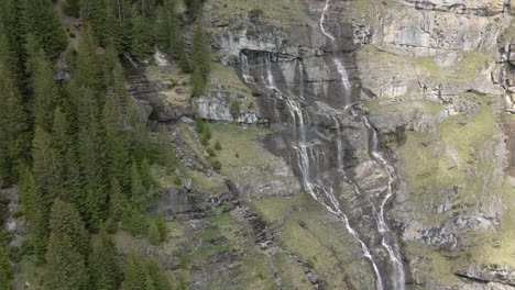 Er-Dreht-Sich-Um-Eine-Malerische-Alpine-Landschaft-Mit-Mehreren-Wasserfällen,-Die-Den-Berg-Hinunterlaufen
