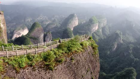 Aerial:-female-hiking-amazing-Bajiao-Shan-mountain-trail,-China-mountain-lookout